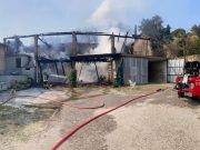 Incendio avvolge una tettoia e raggiunge le case vicine