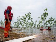 Cina: Hunan, addetti drenano acqua alluvionale in diga lago Dongting
