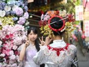 Cina: Fujian, turismo con copricapi floreali